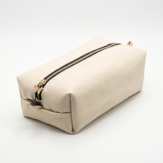 The Élise Beauty Bag in ivory with black zip and gold butterfly detail